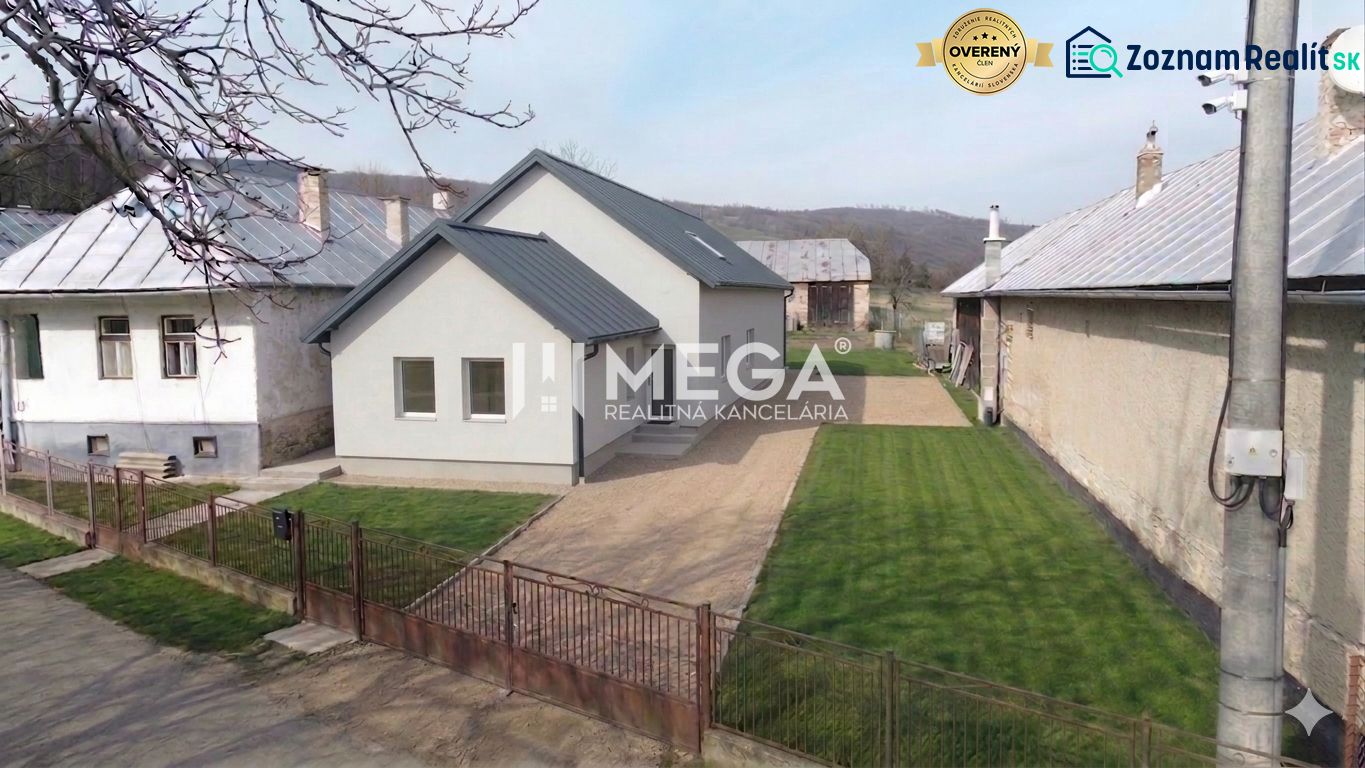 Ein Einfamilienhaus in Zbojná mit Rasen und grauem Dach zwischen zwei benachbarten Gebäuden.