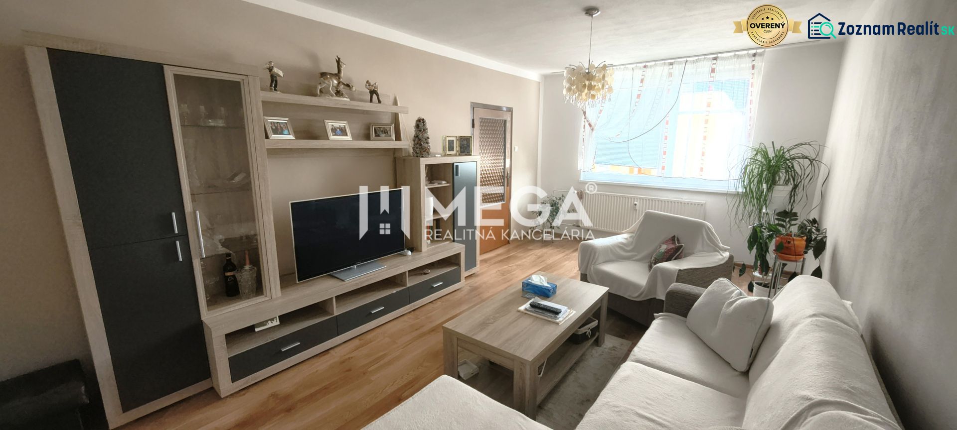 Wohnzimmer mit Sofa, Fernseher und Holzboden in einer 4-Zimmer-Wohnung.