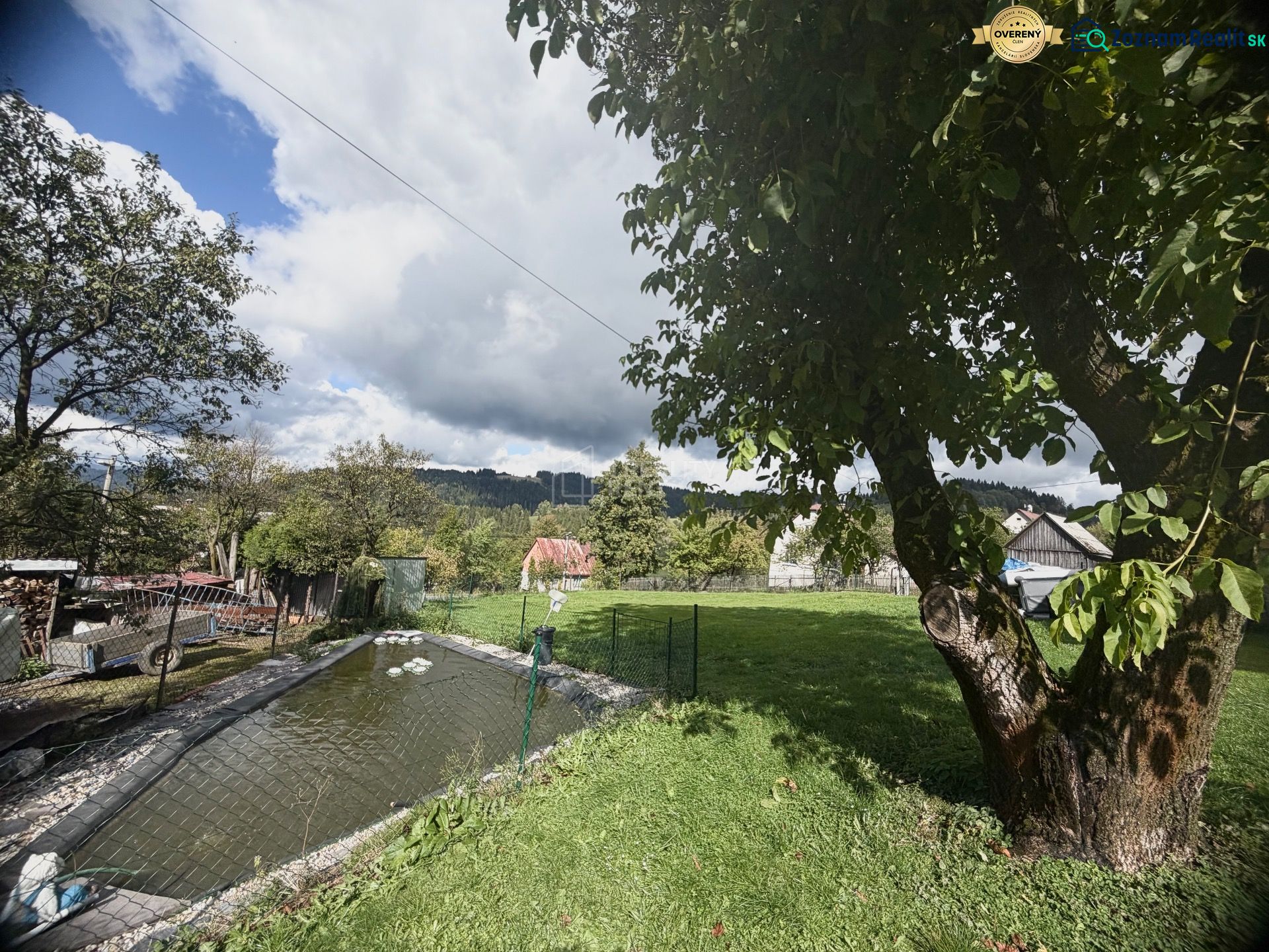 Ein Garten mit einem Teich und Bäumen auf einem Grundstück in Oščadnica in der Straße Košariská.