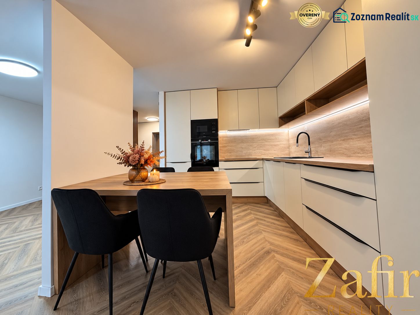 Küche in einer 3-Zimmer-Wohnung mit angenehmer Beleuchtung und einem Boden in Holzoptik.