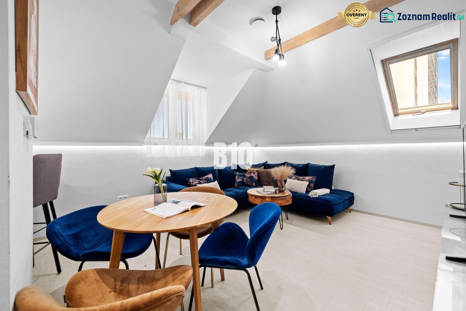 Helles Wohnzimmer in einer Zweizimmerwohnung mit blauem Sofa und Holztisch.