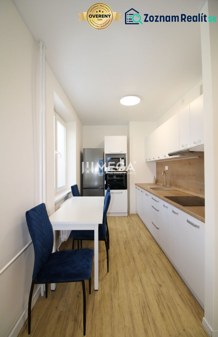 Küche mit weißen Schränken und Holzboden in einer Zweizimmerwohnung.