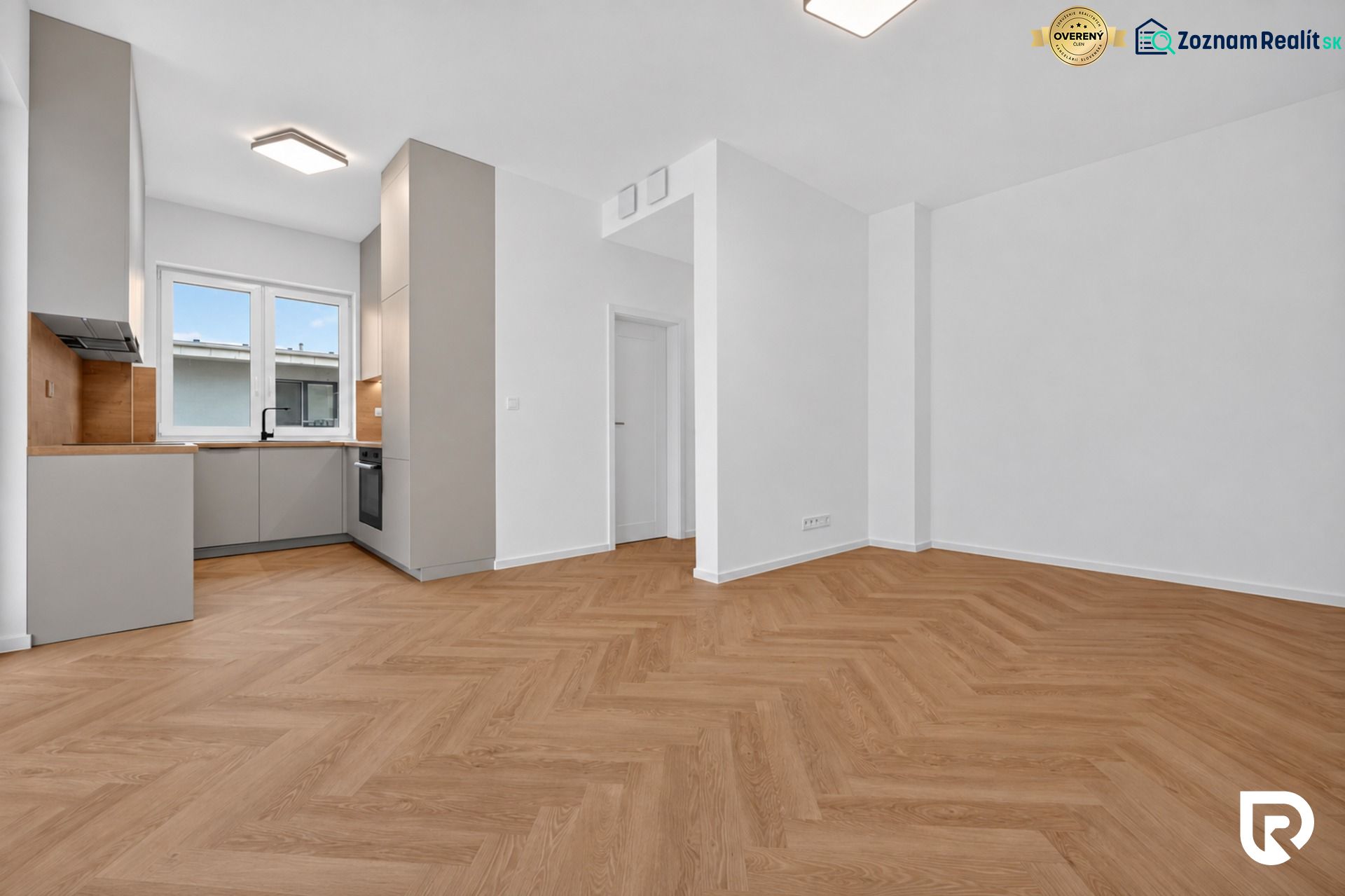 Küche mit eingebauter Küchenzeile und Boden in Holzoptik in einer 3-Zimmer-Wohnung.
