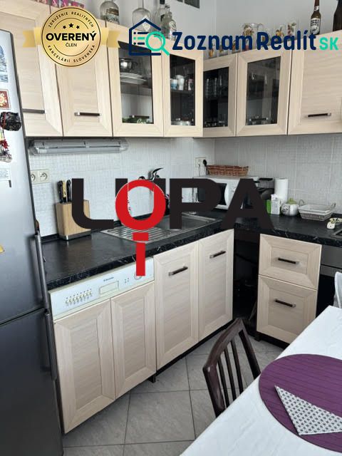 Küche in einer 2-Zimmer-Wohnung mit Holzmöbeldekor und hellen Fliesen.