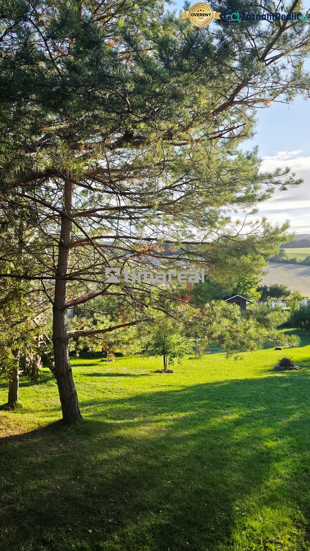 Ein Garten in Dobrá Voda bei einem Einfamilienhaus mit Rasen und Bäumen.