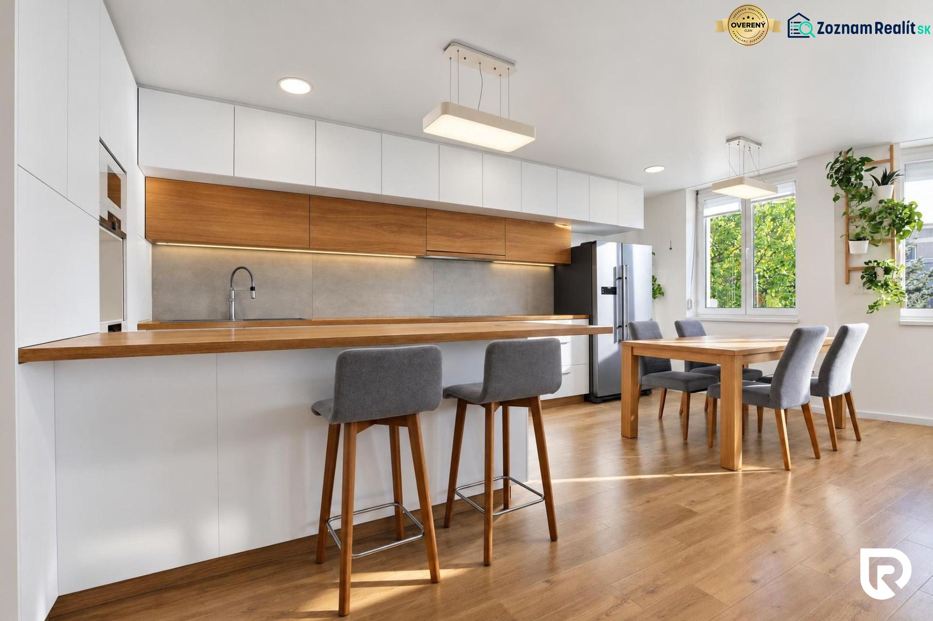 Küche in einer 3-Zimmer-Wohnung mit Holzboden und elegantem Esstisch.