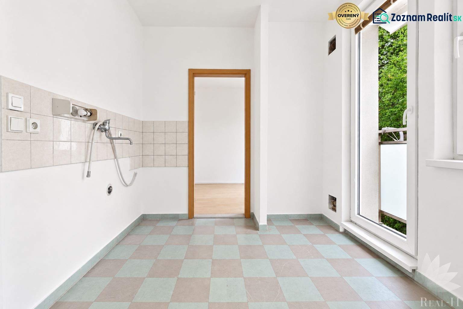 Küche in einer 2-Zimmer-Wohnung mit Fliesen und Balkontür.