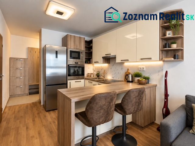 Küche in einer 2-Zimmer-Wohnung mit Geräten und Bodenbelag in Holzoptik.