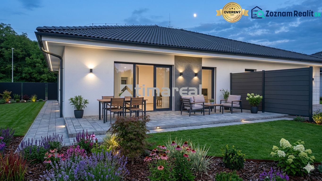Ein Einfamilienhaus in Hôrka nad Váhom mit Terrasse, Beleuchtung und Garten am Abend.