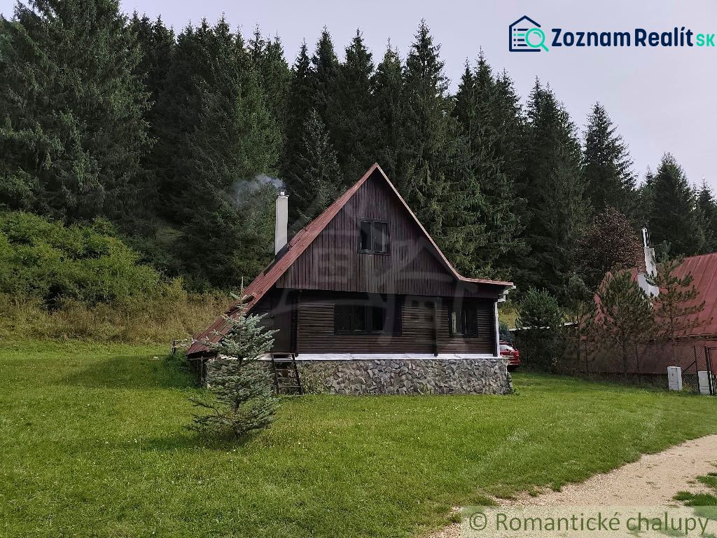 Eine Hütte in Rajecká Lesná, umgeben von Wäldern und einer grünen Wiese.