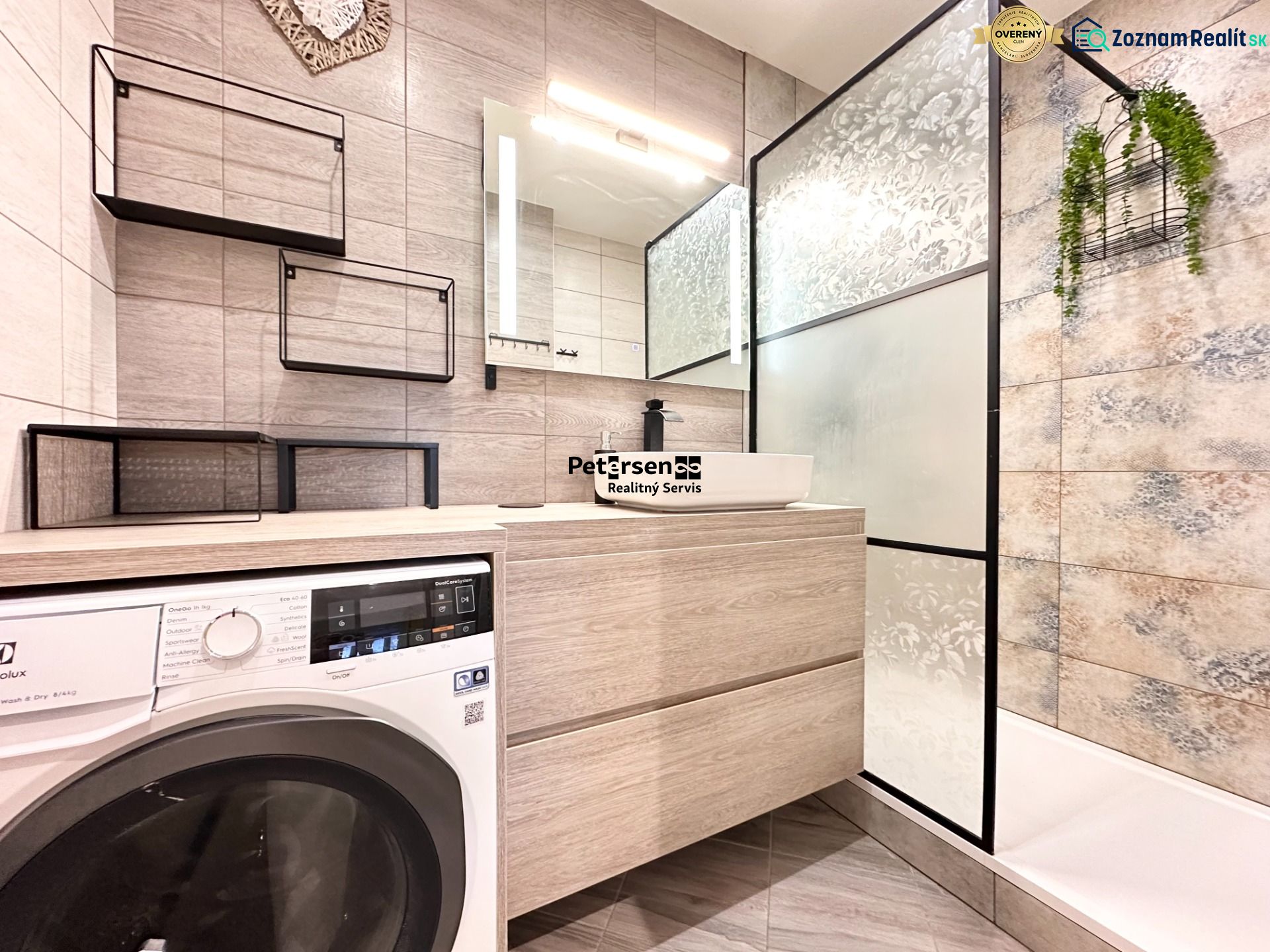 Badezimmer mit Waschmaschine in einer 3-Zimmer-Wohnung; moderne Regale, Duschkabine mit dekorativem Glas.