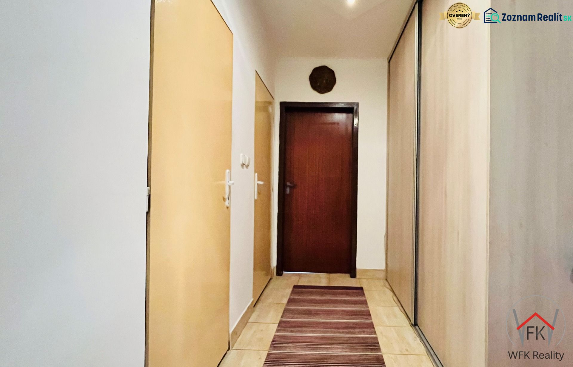 Flur in einer 3-Zimmer-Wohnung mit Stauraum und Teppich in warmen Tönen.
