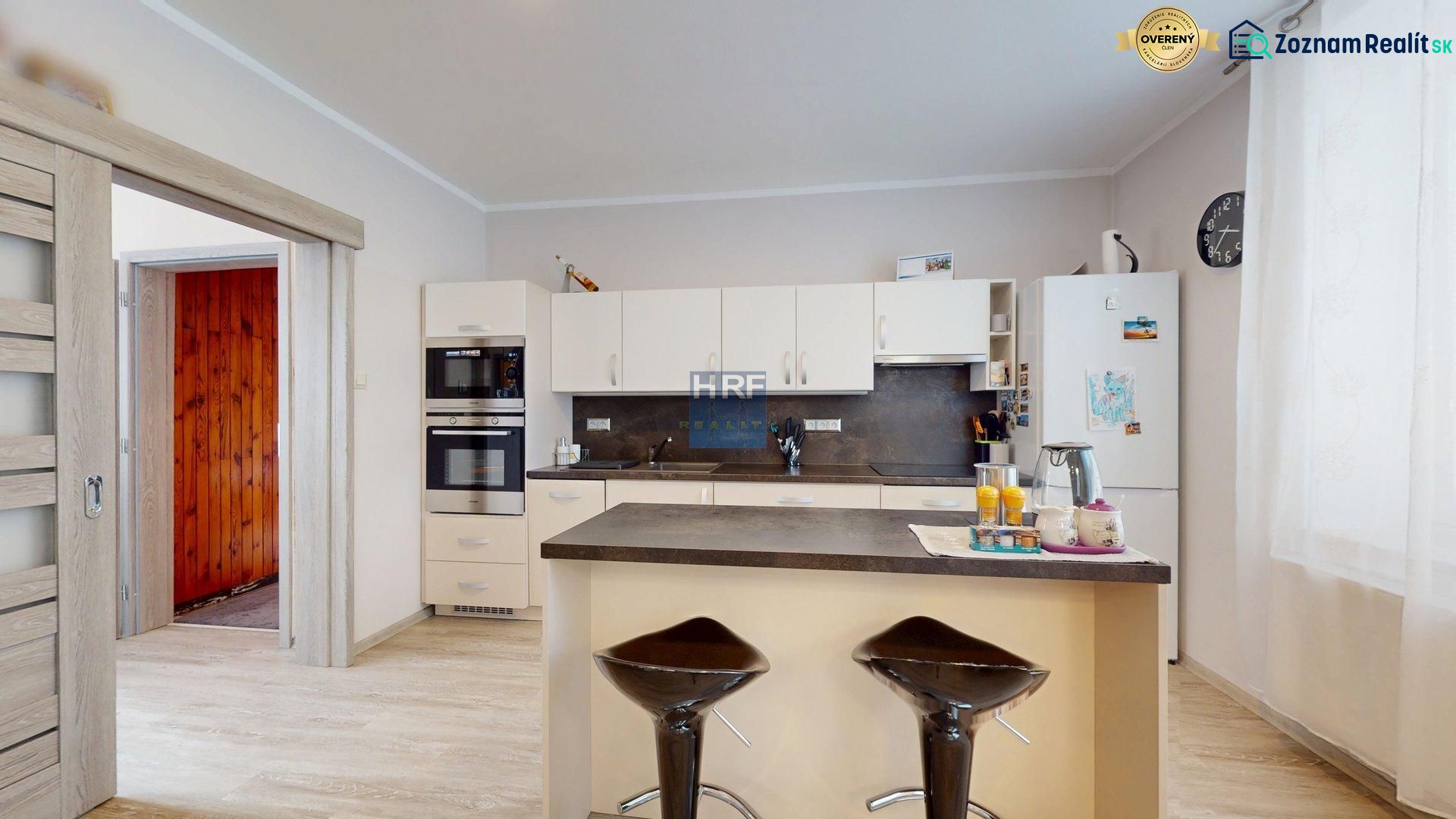 Die Küche in einem Einfamilienhaus mit einem Boden in Holzoptik und modernen Geräten.