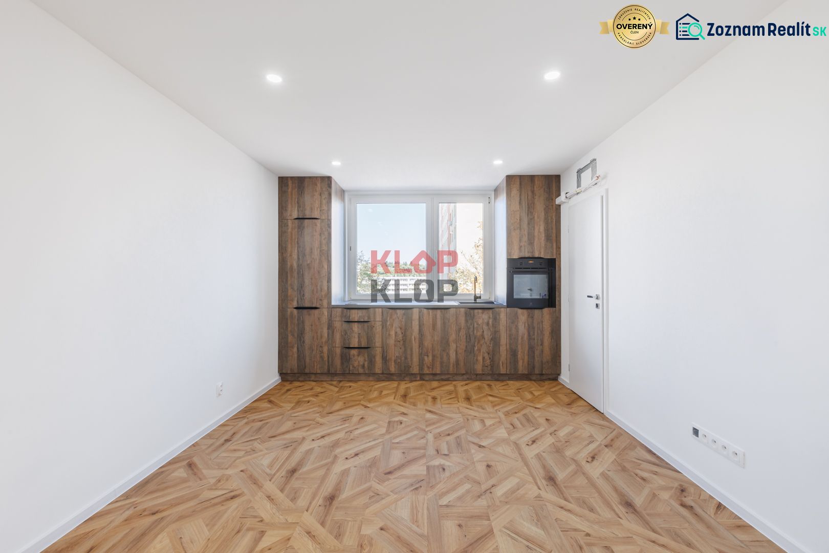 Küche mit Holzboden und eingebauten Geräten in einer 2-Zimmer-Wohnung.