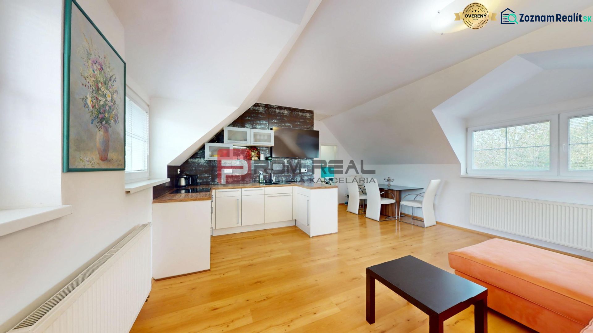 Die Küche mit Wohnzimmer in der 2-Zimmer-Wohnung hat einen Boden mit Holzdekor und Kunst an den Wänden.