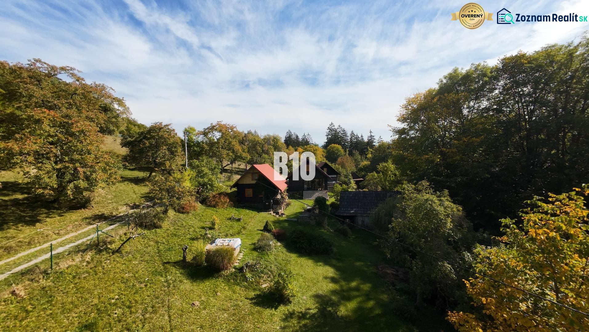 Eine Hütte in Dlhé Pole inmitten einer Waldlandschaft mit blauem Himmel.