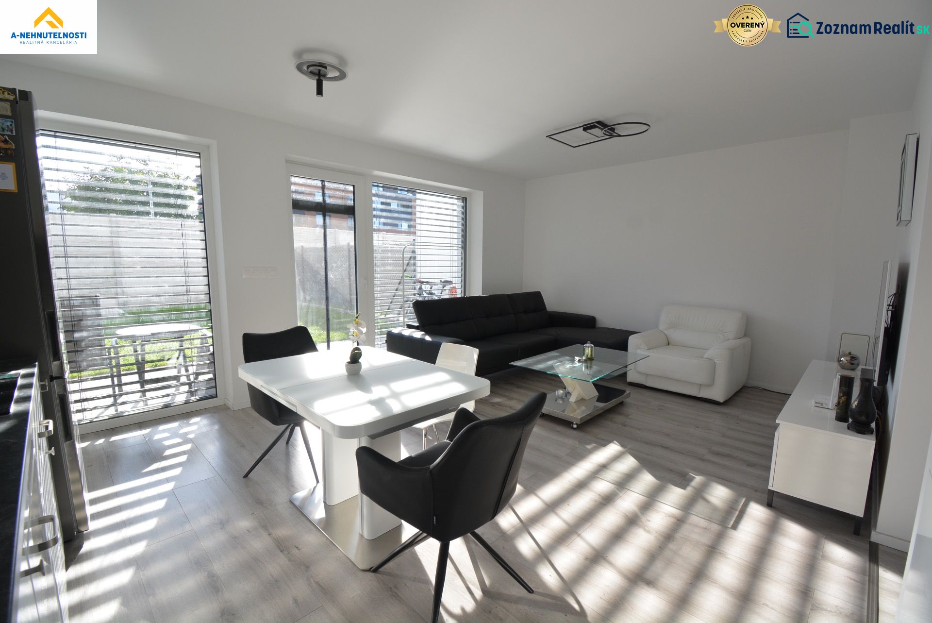 Wohnzimmer in einer 3-Zimmer-Wohnung mit Holzboden und großen Fenstern.
