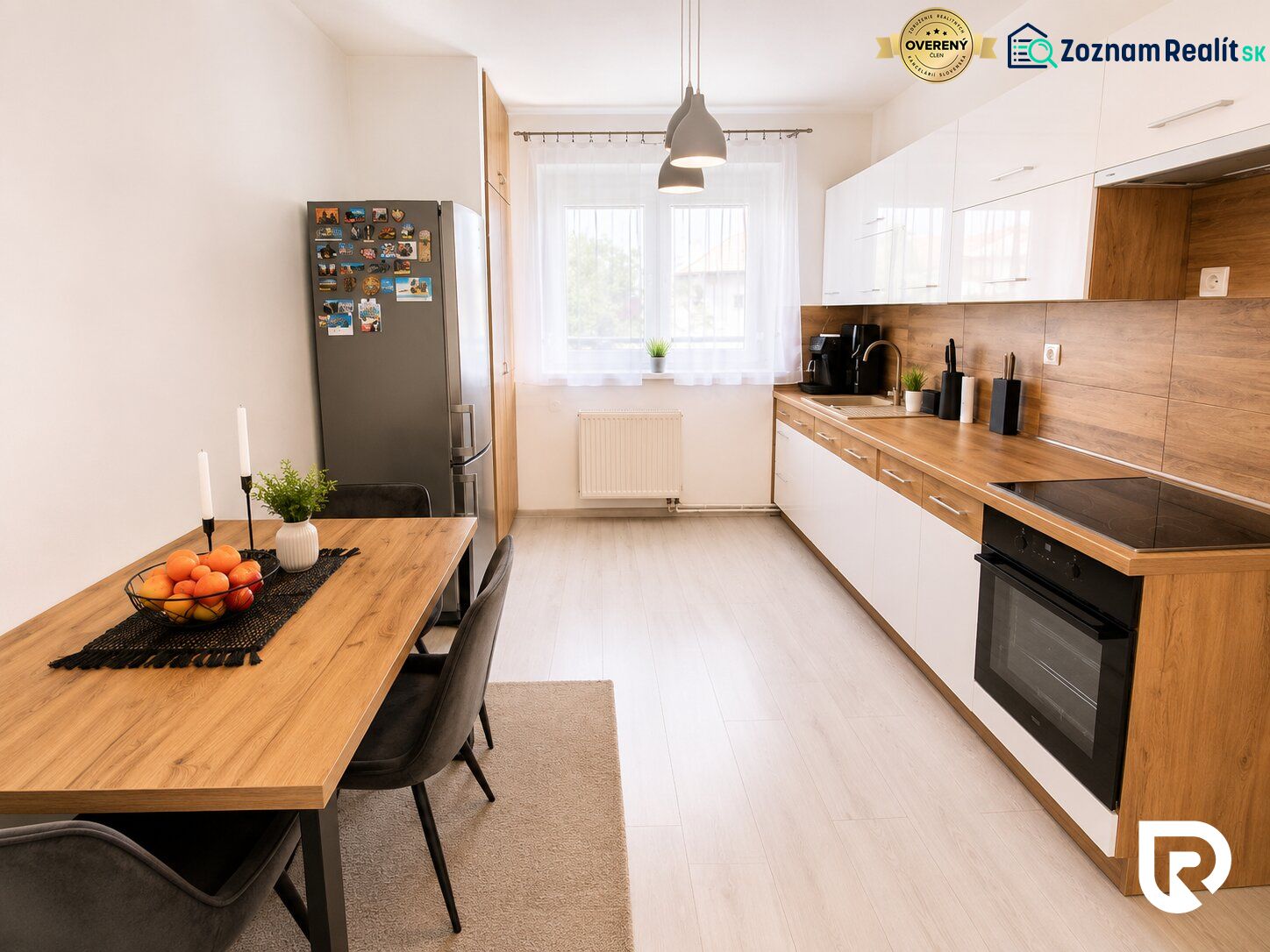 Küche in einer 2-Zimmer-Wohnung mit Holzboden, Esstisch und Geräten.