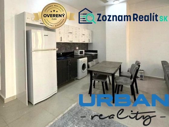 Küche in einer 2-Zimmer-Wohnung mit Esstisch, Kühlschrank und Waschmaschine.