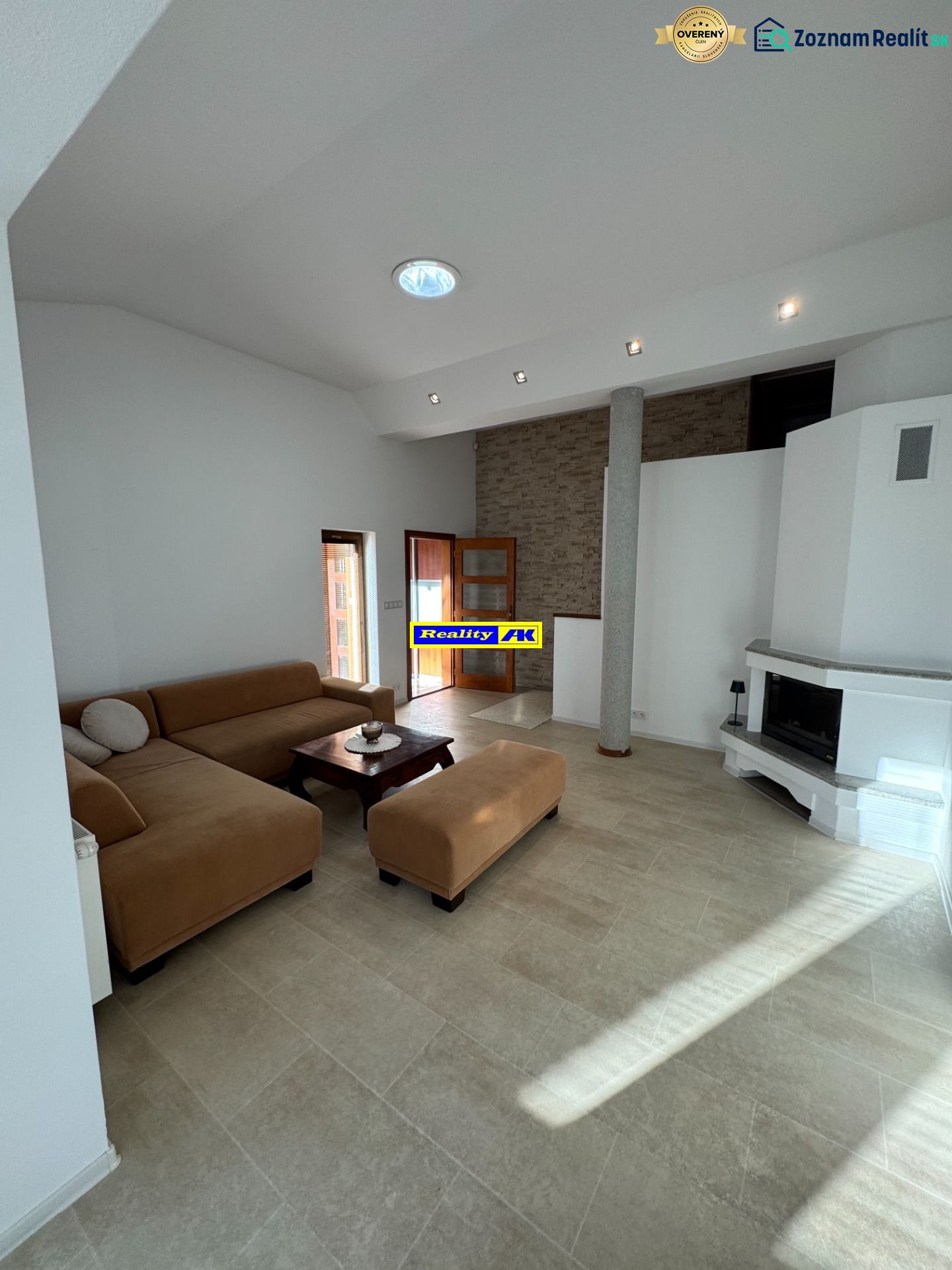 Wohnzimmer in einem Einfamilienhaus mit Kamin und geräumiger Sitzgarnitur.