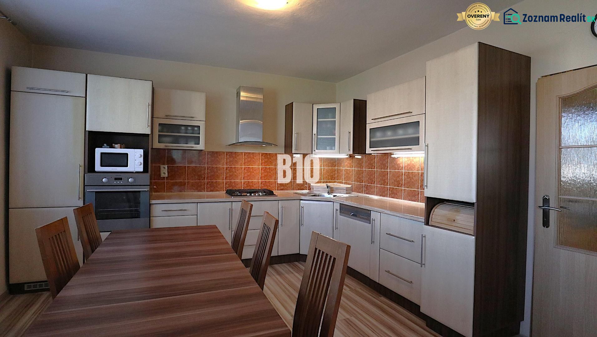 Küche in einem Einfamilienhaus mit Holzdekor und Geräten, mit geräumigem Esstisch.