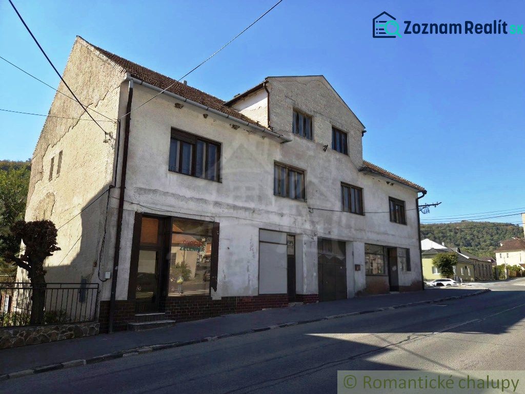 Das Äußere des Gebäudes in Modrý Kameň mit Geschäftsräumen, neben der Straße und der Natur.