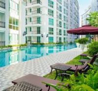 Pattaya, Bau von Wohnungen mit Pool, Liegestühlen und Sonnenschirmen in einem Wohngebiet.
