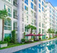 Wohnungsbau in Pattaya: Weißer Wohnkomplex mit Palmen und Pool.