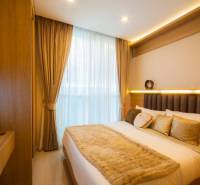 Schlafzimmer mit Bett und Fernseher in einer 3-Zimmer-Wohnung, Interieur in neutralen Farben.