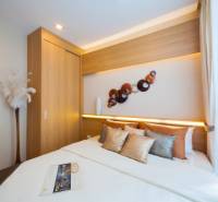Ein Schlafzimmer in einer 3-Zimmer-Wohnung mit einem Einbauschrank und dekorativen Elementen an der Wand.