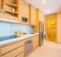Küche in einer 3-Zimmer-Wohnung mit Holzschränken und Geräten.