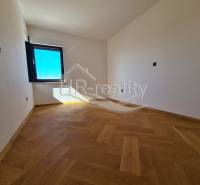Ein Raum mit Holzboden und einem großen Fenster in einer Ferienwohnung.
