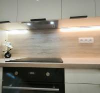 Küchenzeile in einem Einzimmerapartment mit Holzdekor und modernen Küchengeräten.