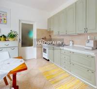 Helle Küche mit Schränken, Esstisch und Dekorationen in einer 4-Zimmer-Wohnung.