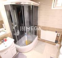 Badezimmer in einem Einfamilienhaus mit Badewanne, Waschbecken, Toilette und Heizung.