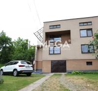 Ein Einfamilienhaus in Brekov mit Garten, Auto und umliegendem Grün.