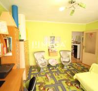 Kinderzimmer im Einfamilienhaus mit buntem Teppich und Möbeln, hellgrüne Wände.