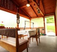 Überdachte Terrasse mit Holzmöbeln und Blumen im Einfamilienhaus.