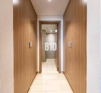 Ein enger Flur mit eingebauten Holzschränken und Blick ins Badezimmer in einer 3-Zimmer-Wohnung.