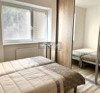Schlafzimmer in einer 3-Zimmer-Wohnung mit zwei Betten und einem Einbauschrank.