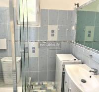 Badezimmer in einer 3-Zimmer-Wohnung mit Dusche, Waschmaschine und Waschbecken.