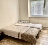 Schlafzimmer in einer 3-Zimmer-Wohnung mit zwei Betten, einem Nachttisch und einem großen Fenster.