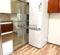 Küche mit Einbauschrank und Kühlschrank in einer 3-Zimmer-Wohnung.