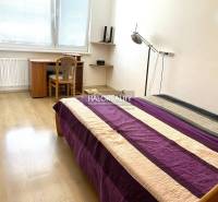Schlafzimmer in einer 3-Zimmer-Wohnung mit Bett, Schreibtisch und Holzboden.