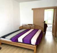 Schlafzimmer in einer 3-Zimmer-Wohnung mit einem Holzbett und Einbauschränken.