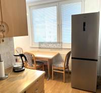 Küche in einer 3-Zimmer-Wohnung mit Kühlschrank, Holztisch und Sesseln.