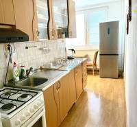 Küche mit Gasherd und Kühlschrank in einer 3-Zimmer-Wohnung, helle Arbeitsplatte.