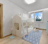 Kinderzimmer in einer 4-Zimmer-Wohnung mit einem Etagenbett und einem blauen Teppich mit Sternen.