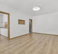 Geräumiges Wohnzimmer mit Holzboden und Zugang zur Küche in einer 4-Zimmer-Wohnung.