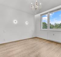 Ein leerer Raum mit Holzboden, Kronleuchter und großem Fenster, 4-Zimmer-Wohnung.